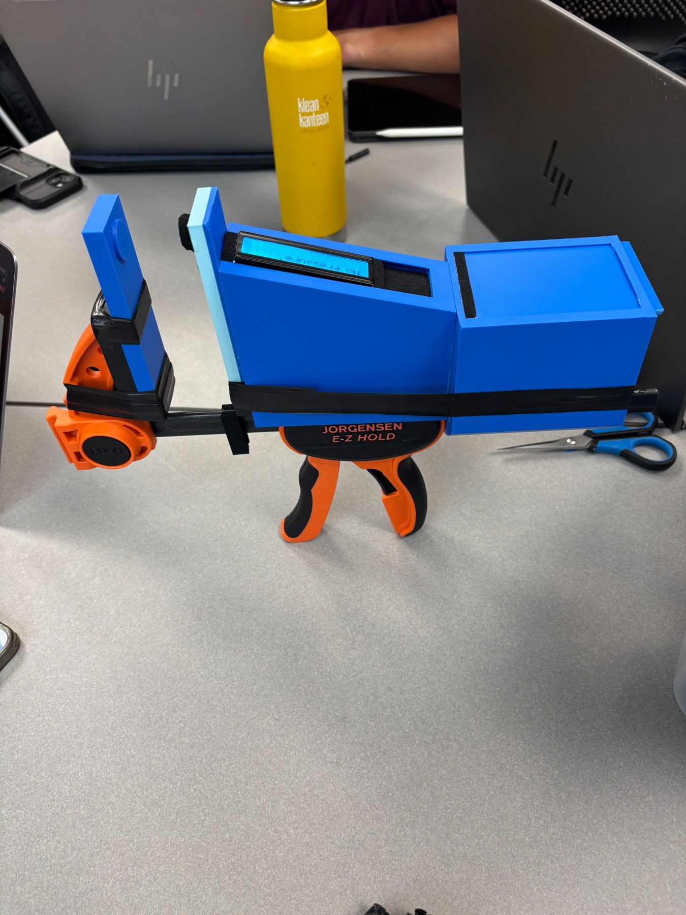 Completed team prototype with printed casing, clamp, and digital display.